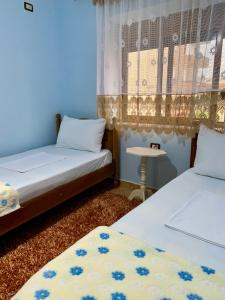 a room with two beds and a table in it at Guest House Dimos Kristi in Përmet