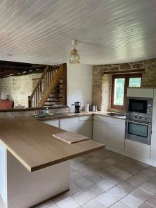 a large kitchen with a counter and a stove at Grande maison type Périgourdine in Montignac
