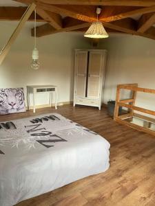 a bedroom with a bed and a wooden floor at Grande maison type Périgourdine in Montignac