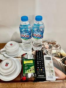 - une table avec 2 bouteilles d'eau et une télécommande dans l'établissement Khách Sạn Trung Anh 78 HAI BÀ TRƯNG BMT, à Buôn Ma Thuột