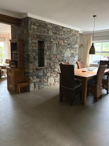 a dining room with a table and a stone wall at Shanakeever Farm - 3 Bedroom Apartment in Clifden