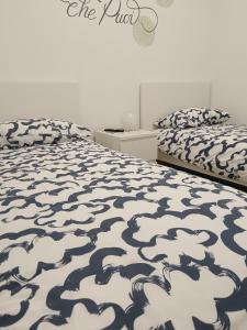 um quarto com 2 camas com lençóis brancos e pretos em B&B COLLE TARIGNI em Manoppello