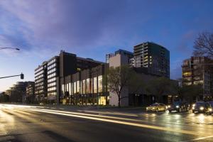 a city street with cars driving down a street with tall buildings at Pullman Melbourne Albert Park in Melbourne