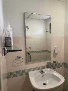 een badkamer met een wastafel en een spiegel bij Lovly Couple Sea View w Netflix in Port Dickson