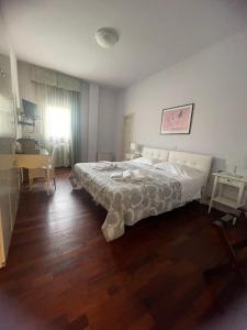 a bedroom with a large bed and a desk at L'Approdo Hotel in Cesenatico