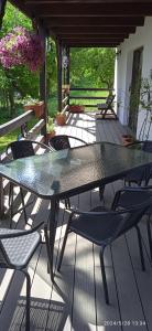 une table et des chaises en verre sur la terrasse dans l'établissement Agroturystyka Nad Czarnym, à Giby