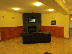 a living room with a fireplace and a couch at Trend Mountain Hotel & Conference Centre in Tumbler Ridge