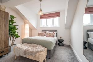 a bedroom with a bed and a chair and windows at Central Belfast Apartments: Botanic in Belfast