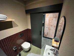 een badkamer met een toilet, een wastafel en een spiegel bij BKM Hostel in Istanbul