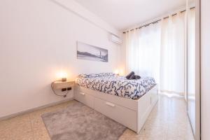 a white bedroom with a bed and a window at Lungotevere Apartment in Rome