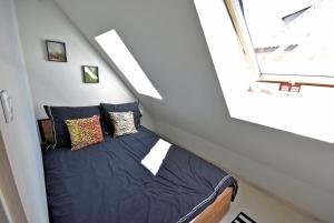 Łóżko w małym pokoju z oknem w obiekcie Apartamenty Basztowa w Świdnicy