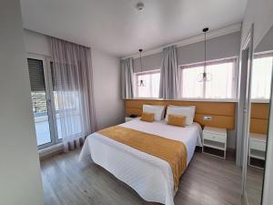 a bedroom with a large bed with two pillows at Hotel Aleluia in Fátima