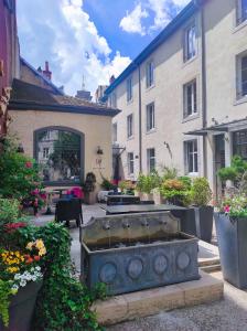 ブザンソンにあるオテル ド パリの噴水のある中庭と一部の建物