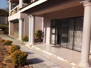 una casa con portico con colonne e piante di Protea Avenue Margate a Margate