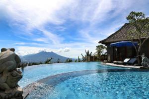a pool at a resort with mountains in the background at PURI BALI STANIA, Cisarua West Java in Cilama