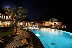a large swimming pool at night with chairs around it at PURI BALI STANIA, Cisarua West Java in Cilama