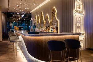 a bar in a restaurant with stools at Motel One Rostock in Rostock