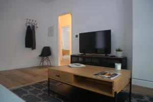 a living room with a tv and a coffee table at Apartamentos As Barxas Playa in Moaña