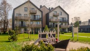an apartment building with a playground in front of it at Apartament RAINBOW SurfingBird Dźwirzyno in Dźwirzyno