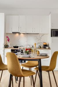 Una cocina con una mesa y sillas con copas de vino. en ARI Navy Apartment - High-end Residence, en Arad