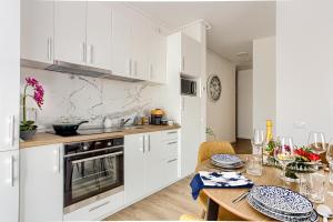 Una cocina con gabinetes blancos y una mesa de madera. en ARI Navy Apartment - High-end Residence, en Arad 34 fotos más