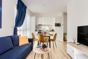 Una sala de estar con un sofá azul y una mesa. en ARI Navy Apartment - High-end Residence, en Arad