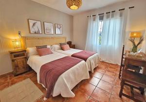 - une chambre avec 2 lits et une fenêtre dans l'établissement Los Molinos, à Sanlúcar de Guadiana