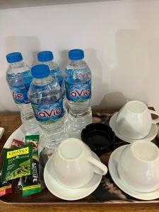 ein Tablett mit zwei Flaschen Wasser sowie Teller und Schüsseln in der Unterkunft Khách Sạn Trung Anh 78 HAI BÀ TRƯNG BMT in Buon Ma Thuot