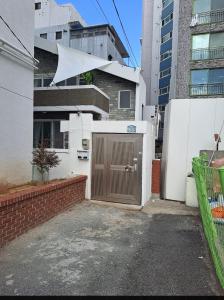 un garaje con una puerta marrón frente a un edificio en Soban Stay en Busan