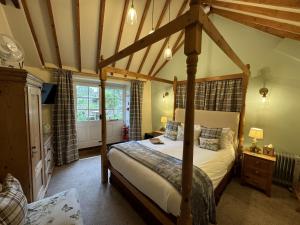 una camera con letto a baldacchino di Guiting Guest House a Guiting Power