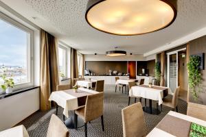 a restaurant with tables and chairs and windows at Hotel Am Parkring in Vienna