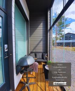 eine Veranda mit einem Hocker und einem Fenster in der Unterkunft Safaritalo Cottages in Kalajoki