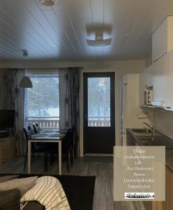 eine Küche und ein Esszimmer mit einem Tisch, einer Küche und einem Esszimmer in der Unterkunft Safaritalo Cottages in Kalajoki