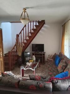 a living room with a couch and a staircase at Eni's Villa, 5km From Shengjini Beach in Lezhë