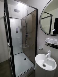 uma casa de banho com um chuveiro, um lavatório e um espelho. em Anaïs Hôtel Bourges Nord Saint-Doulchard em Bourges