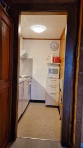 a kitchen with white appliances and a clock on the wall at Studio Luizet Nr 28 in Leukerbad