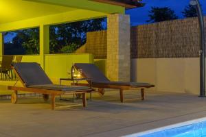 zwei Liegestühle neben einem Pool in der Unterkunft House Gorana by IstriaLux in Bibići
