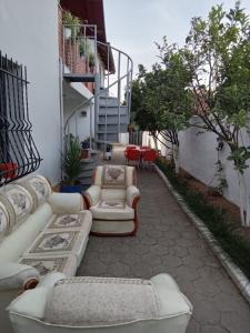 un patio avec des canapés et des tables dans un bâtiment dans l'établissement Eni's Villa, 5km From Shengjini Beach, à Lezhë