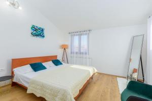 ein Schlafzimmer mit einem Bett mit blauen Kissen und einem Spiegel in der Unterkunft House Gorana by IstriaLux in Bibići + 32 Fotos