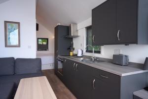 a kitchen with black cabinets and a table and a couch at Carrickreagh Bay in Blaney +11 photos