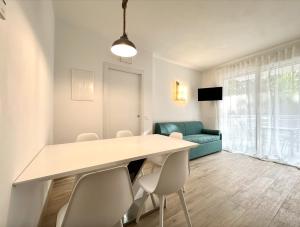 a dining room with a table and chairs and a couch at Residence Eva - Carraro Immobiliare Jesolo - Family Apartments in Cavallino-Treporti