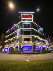 een hotelgebouw met 's nachts een bord bij HOTEL SRI SUTRA (BANDAR SUNWAY) in Petaling Jaya