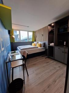 Habitación de hotel con cama y mesa de cristal en Pro Messe Hotel Hannover, en Hannover