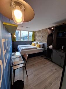 ハノーファーにあるプロ メッセ ホテル ハノーファーのベッドとガラスのテーブルが備わるホテルルームです。
