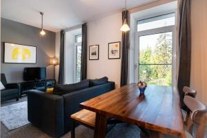 un soggiorno con tavolo e divano di TATRYSTAY Oliver Apartments a Štrbské Pleso