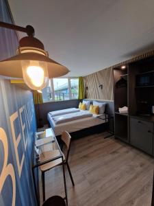 ein Schlafzimmer mit einem Bett, einem Tisch und einem Stuhl in der Unterkunft Pro Messe Hotel Hannover in Hannover
