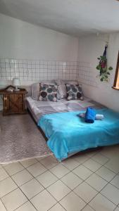 a bedroom with a large bed with a blue blanket at Szalupa Hostel Airport in Zakroczym