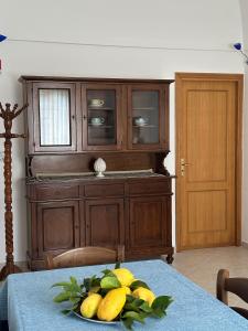 a table with a wooden cabinet and a plate of fruit at Da Nonna Luciana in Scala +8 photos