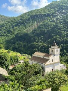 a small white building in front of a mountain at Da Nonna Luciana in Scala