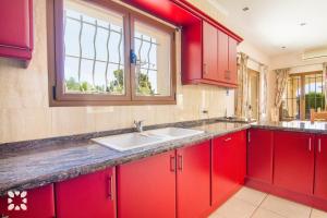 a red kitchen with a sink and a window at Villa Medina 20 by Abahana Villas in Moraira